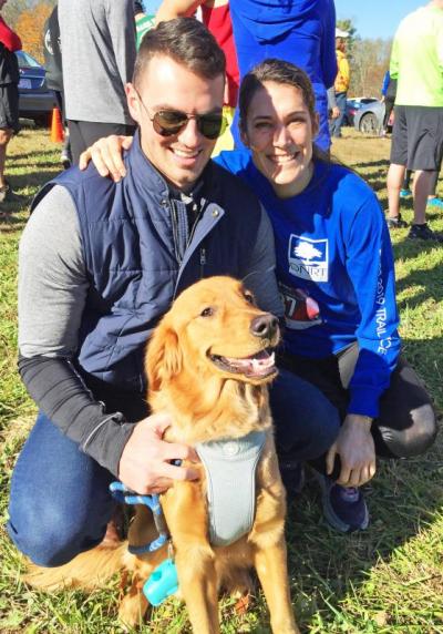 Chad Urlaub and 10-month-old puppy Mac support Boston runner Amy Steele before the race. Steele went on to win as the top female runner.