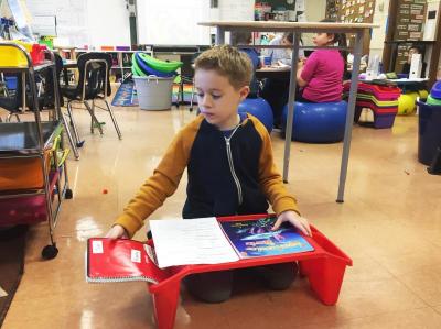 Tyler Calvao, 8, uses a sitting desk.
