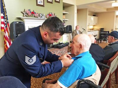 Dartmouth Veterans Advisory Board chair Chris Pereira pinning an American Flag pin to Ed Mello’s lapel during a ceremony to honor veterans on November 11.