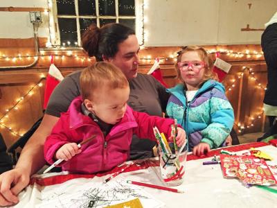 Dartmouth, MA news - Nolan Sideleau, 1, writes a letter to Santa at the workshop while mom Hope and sister Phoebe, 3, help.