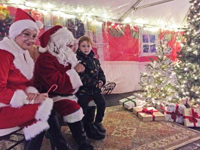 Leland Hathaway, 5, telling Santa and Mrs. Claus what he wants for Christmas.