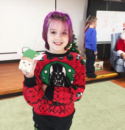 Dartmouth, MA news - Christmas at Southworth Library - Penelope Diotte-Arsenault, 8, of New Bedford shows off her elf ornament, which she named “Sugar Plum”.