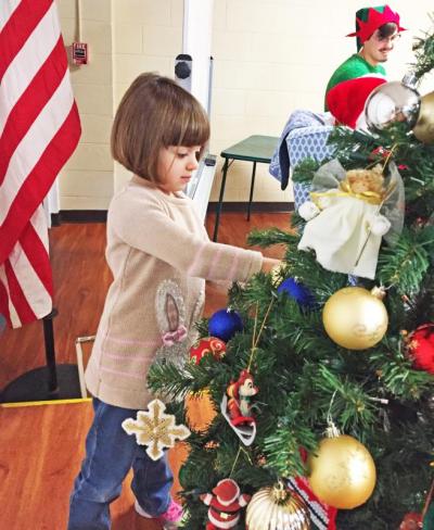 Dartmouth, MA news - Christmas at Southworth Library - Acushnet resident Victoria Martins, 4, decorates the tree.