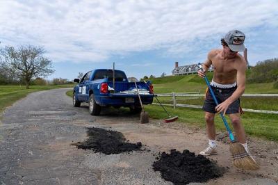 One of Mello’s photos of a Cuttyhunk Shellfish employee filling potholes on the island. Photo by: Phil Mello, Big Fish Studio