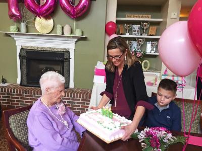Kim Keaney puts the cake in front of her grandmother at the party