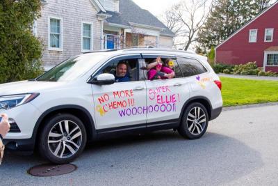 Superheros wave from a car painted with congratulatory messages. Photo by Jennifer Lima Photography