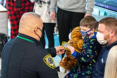 School Resource Officer David Tavares gives Landon a stuffed tiger and Dartmouth Police patch. Photo by: Morgan Beard.