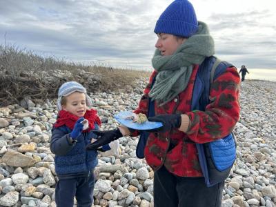 (from left) Samuel Saltos shares his collection of sea shells with Cara Liberatore during the Lloyd’s Center 33rd Annual New Year’s Day beach walk.