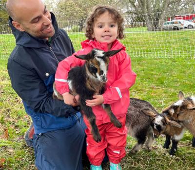 Dan Burgo and his 2-year-old daughter Isabella enjoy a petting zoo filled with baby Nigerian Dwarf Goats at Round the Bend Farm on Saturday, April 20. Photo by Justice Burnaugh