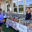 Carrie Richter from PeachTree Circle Farm in Falmouth speaks with a customer about her pickled goods. Richter brought several varieties of garlic to the party.