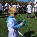 Three-year-old Brady Polochick gets ready to throw some teal color on those finishing the run.