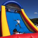 A child slides down the bounce house obstacle course.