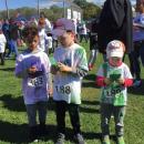 Nicholas DaRosa, 6, and Owen Valois, 6, with his four-year-old brother Benjamin all examine their color packets before the post-run celebration.