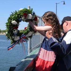 Dartmouth Week - Dartmouth, MA news - Lauren Rose-Wells and her grandfather, Norman Giovannini conduct the wreath throwing ceremony on the Padanaram Bridge. Photo by: Douglas McCulloch