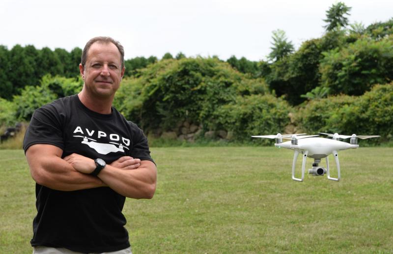 Anthony Franco poses for a photo next to his drone as it hovers nearby. BY DOUGLAS MCCULLOCH
