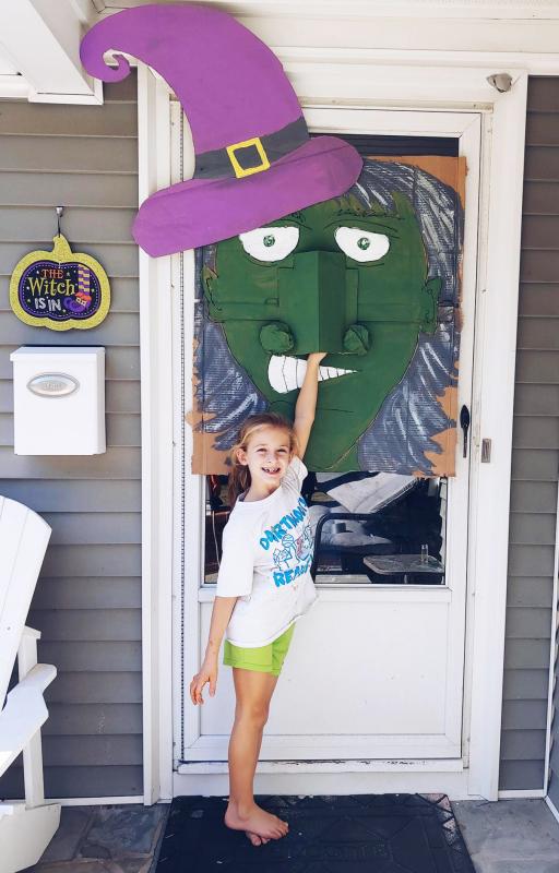 Sophia Dutra, 7, testing out the family’s socially distant Halloween decoration for trick-or-treaters to receive candy from a witch’s nose. Courtesy: Rebecca Dutra