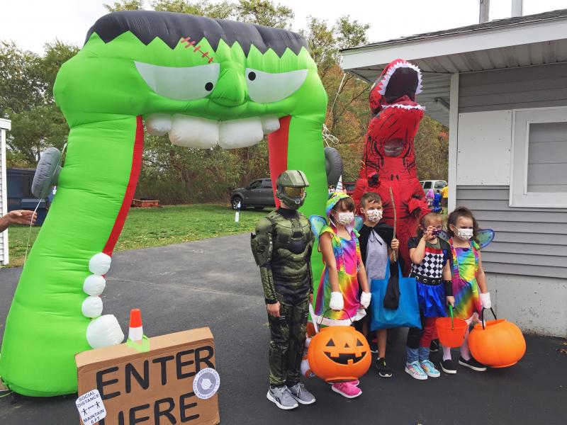 A family poses for a photo at the entrance to the Trunk or Treating event. Dartmouth Week - Dartmouth, MA news - A family poses for a photo at the entrance to the Trunk or Treating event.