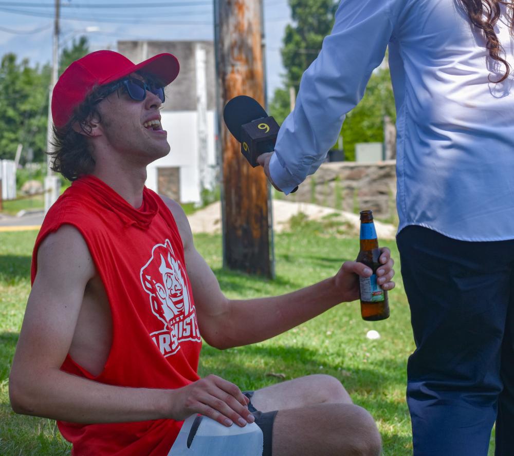 Tyler Murphy sits for an interview after earning his team a run with no shoes on.