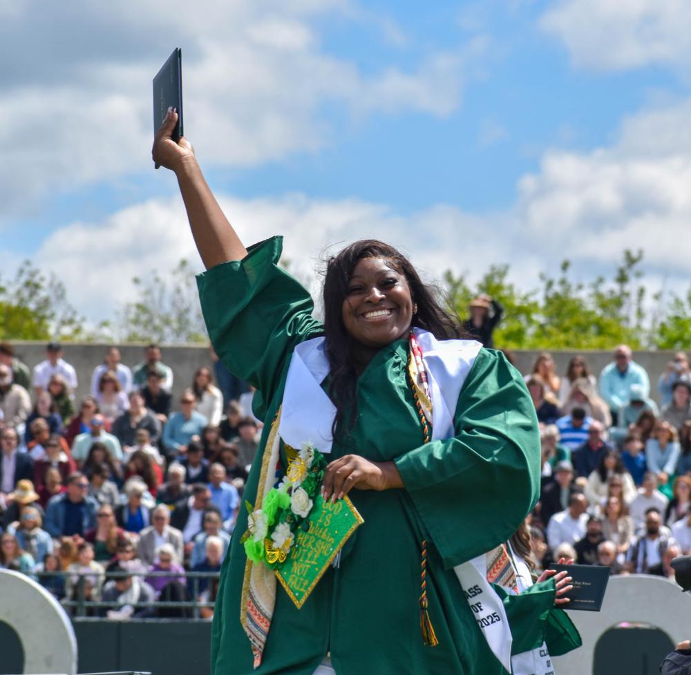 Reyana Boyard waves her diploma in the are after graduating.
