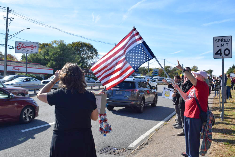 A woman waves an upside down flag signaling distress. A woman waves an upside down flag signaling distress.