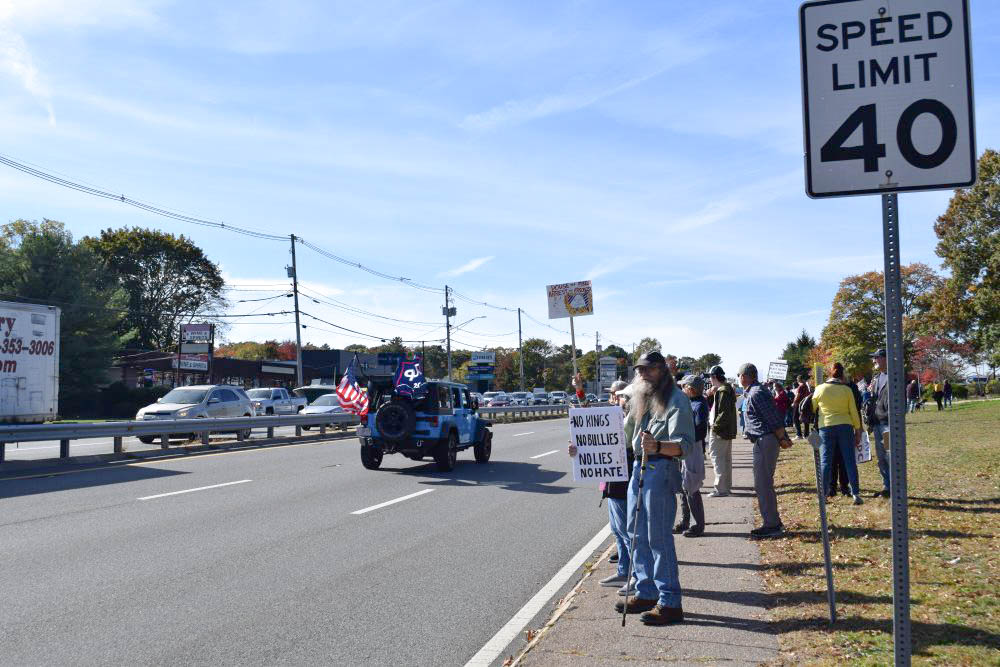 People protest as a Trump-flag-waving truck drives past. People protest as a Trump-flag-waving truck drives past.