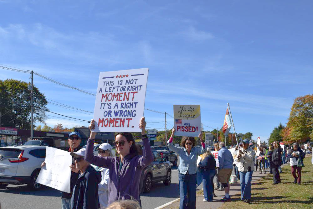 People walk along the road with their signs. Photos by Kat Sheridan