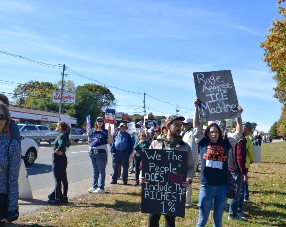The crowd gathers at the corner of Faunce Road and the mall with their signs and protest shirts. The crowd gathers at the corner of Faunce Road and the mall with their signs and protest shirts.
