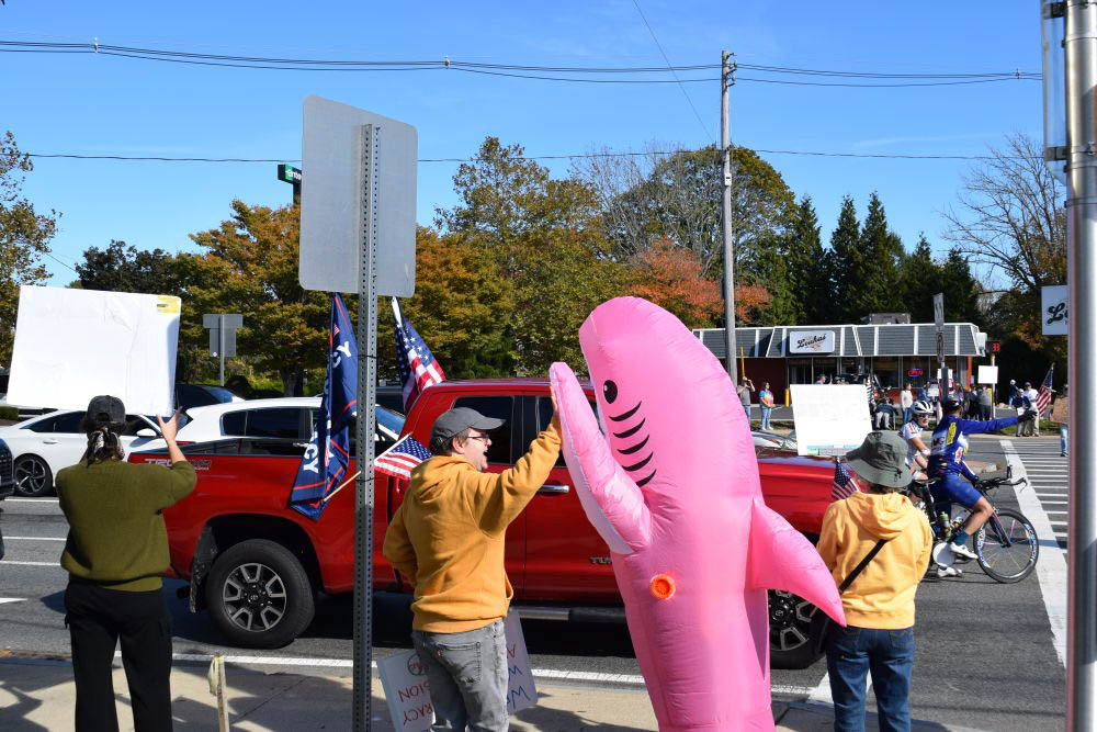 Two protesters high five in front of a Trump supporter. Two protesters high five in front of a Trump supporter.
