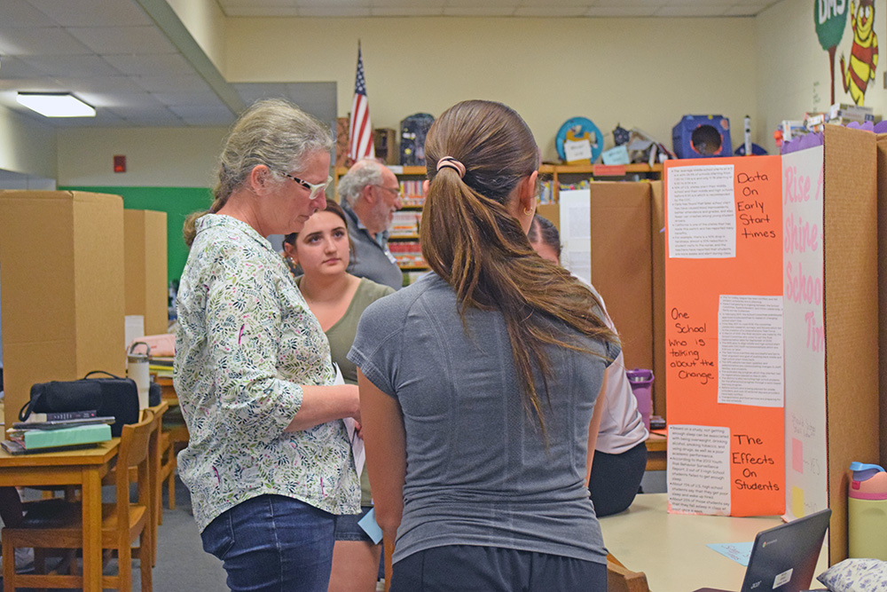 Students present their project to Elizabeth Coughlin. 