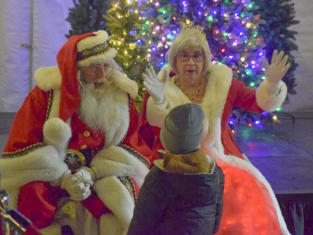 Santa and Mrs. Claus talk to a child.