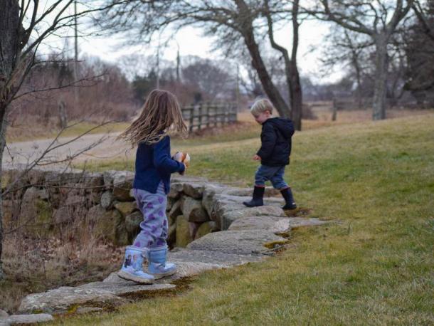Two children run along the stone fence at Round the Bend Farm. Photos by Kat Sheridan