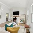 Open living room with a lit pellet stove, looking toward the renovated kitchen at 226 Sanford Road, Westport