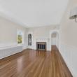 Unit 2 living room with hardwood floors, wainscoting and a fireplace at 370 Maple Street, New Bedford