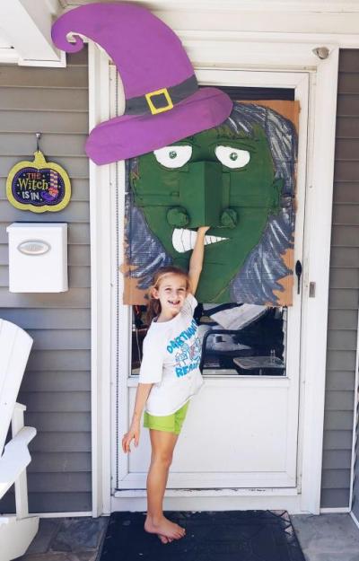 Sophia Dutra, 7, testing out the family’s socially distant Halloween decoration for trick-or-treaters to receive candy from a witch’s nose. Courtesy: Rebecca Dutra