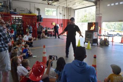 A firefighter instructs residents how to put out a grease fire.