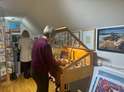 Linda Mae Kristofik stocking some of her jewelry in a case. 