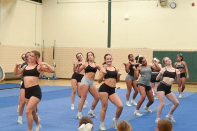 The cheerleaders practice their routine. 