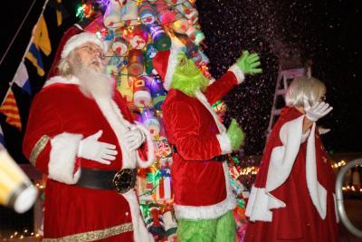 The Grinch and Clauses wave to the crowd in front of the buoy tree. Photo by Michael T. Morris Photography