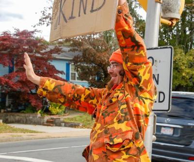 Bean waves to a passing car.