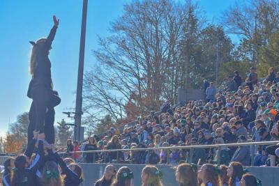 A cheerleader stunts for the crowd. 