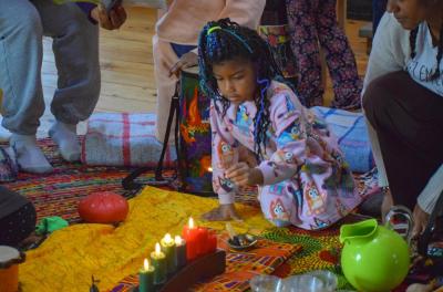 Sonora Strachan, 7, lights a Kwanzaa candle. 