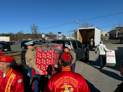 The marines load the toys onto a truck for transport.