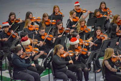 The orchestra students perform while dressed for Christmas.