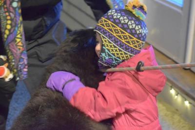 Aurora Cove, 2.5, gives a dog a hug.