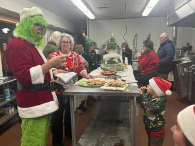 Lincoln Manely peeks at the Grinch from behind the cookie table. 