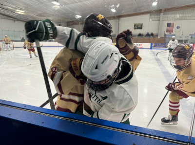 Opposing players wrestle against the glass. 