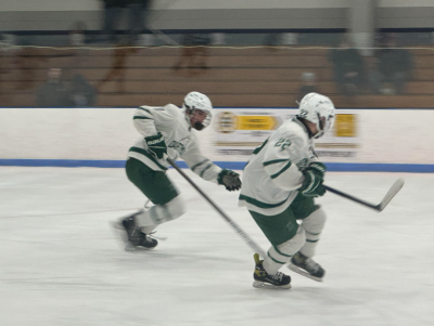 Two players skate after the puck. Photos by Kat Sheridan