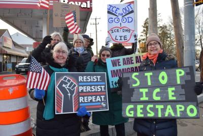 A number of protesters pose with their signs. 