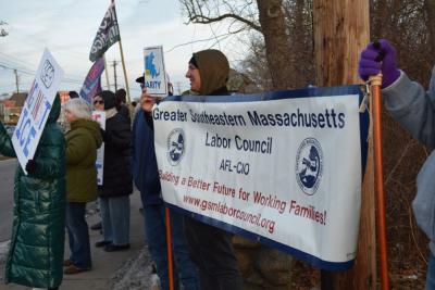 A labor organization holds their sign.