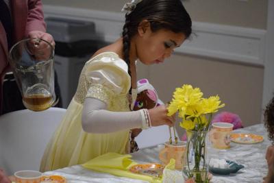 Kehlani Semedo, age 5, adds a bit more sugar to her tea.